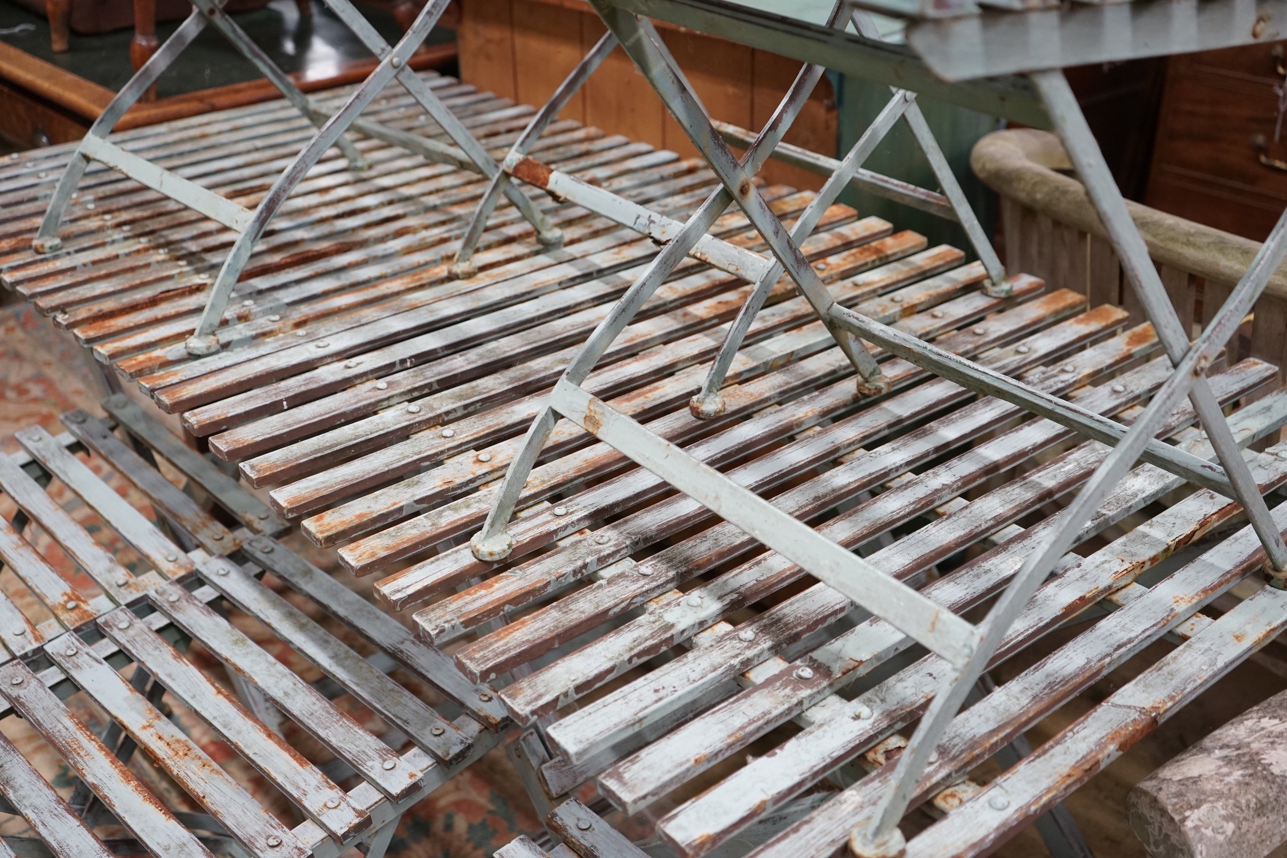 A pair of rectangular painted metal slatted garden tables, each width 86cm, depth 87cm, height 74cm and six matching folding chairs